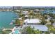 Waterfront estate featuring a private dock, swimming pool, lush landscaping, and city skyline in a peaceful neighborhood at 31 Dolphin Dr, Treasure Island, FL 33706