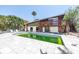 A unique two-story home features a spacious pool and a wooden deck perfect for entertaining guests at 31 Dolphin Dr, Treasure Island, FL 33706