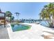 Waterfront home featuring a pool, lounge chairs, and a private dock overlooking calm waters at 31 Dolphin Dr, Treasure Island, FL 33706