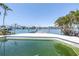 Beautiful waterfront home featuring a private dock and a pool surrounded by palm trees at 31 Dolphin Dr, Treasure Island, FL 33706