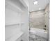 Bathroom featuring shower-tub combo, open shelving, and decorative tile floors at 3102 W Horatio St # 13, Tampa, FL 33609