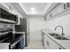 Bright kitchen featuring stainless steel appliances, subway tile backsplash, and white cabinetry at 3102 W Horatio St # 13, Tampa, FL 33609