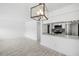 Living room and kitchen featuring white walls, modern light fixture, and tile flooring at 3102 W Horatio St # 13, Tampa, FL 33609