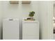 Practical laundry area with modern washer and dryer and decorative plant at 31596 Griffin Sands Ln, San Antonio, FL 33576