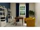 Stylish home office featuring a sleek desk, bright window, and comfortable yellow armchairs at 31748 Griffin Sands Ln, San Antonio, FL 33576