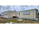 Rear exterior of the home shows an AC unit and space for outdoor activities or storage at 3301 Alt 19 # 500, Palm Harbor, FL 34683