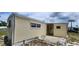 View of the home's side and back reveals a small patio area at 3301 Alt 19 # 500, Palm Harbor, FL 34683