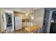 Kitchen featuring white appliances, wooden cabinets, and an island counter with additional storage at 3301 Alt 19 # 500, Palm Harbor, FL 34683