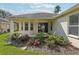 A charming backyard featuring a covered patio with sliding glass doors and a garden bed filled with vibrant red roses at 3311 Stonebridge Trl, Valrico, FL 33596