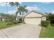 A well-maintained home with a two-car garage, a concrete driveway, and a green lawn with neatly trimmed bushes at 3311 Stonebridge Trl, Valrico, FL 33596
