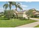 Manicured front yard with lush lawn, mature palm trees, and decorative shrubs enhancing curb appeal at 3311 Stonebridge Trl, Valrico, FL 33596