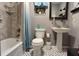 Cozy bathroom featuring a pedestal sink, toilet, and a tiled tub-shower with stylish fixtures at 3411 W Beach St, Tampa, FL 33607