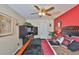 Bedroom featuring a red accent wall and a ceiling fan with dark wood furnishings for storage at 3411 W Beach St, Tampa, FL 33607