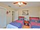 Bedroom with twin beds, wood floors, and a ceiling fan for comfortable living and natural light at 3411 W Beach St, Tampa, FL 33607
