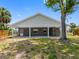 Rear exterior of home featuring covered patio, columns, dark exterior paint, and green lawn at 366 12Th Ave, Indian Rocks Beach, FL 33785