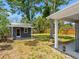 View of backyard featuring additional building, green grass and shaded trees at 366 12Th Ave, Indian Rocks Beach, FL 33785