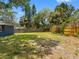 An ample-sized backyard is surrounded by a wooden fence with palm trees providing a tropical feel at 366 12Th Ave, Indian Rocks Beach, FL 33785