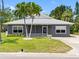 Charming single-story home with a well-maintained lawn, palm trees, and gray exterior at 366 12Th Ave, Indian Rocks Beach, FL 33785