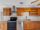 A view of the modern kitchen featuring wooden cabinetry, tile backsplash, and stainless steel appliances at 366 12Th Ave, Indian Rocks Beach, FL 33785