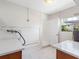 Functional laundry room with white countertops, sink, window, and tile flooring at 366 12Th Ave, Indian Rocks Beach, FL 33785