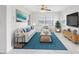 Bright living room featuring a modern sofa, stylish rug, and a flat-screen TV for comfortable entertaining and relaxation at 366 12Th Ave, Indian Rocks Beach, FL 33785