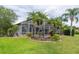 Well maintained backyard featuring a screened lanai, lush landscaping, and lawn at 3716 Janus Way, Palm Harbor, FL 34685