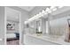 Bathroom featuring double sinks, a large mirror, and bright lighting with a bedroom view at 3716 Janus Way, Palm Harbor, FL 34685