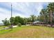 Beautiful community lawn with palm trees, pavilion, and walkway under a cloudy sky near the shore at 3716 Janus Way, Palm Harbor, FL 34685