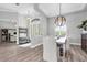 Elegant dining room with stylish lighting fixture, and an entryway with half-moon window above the door at 3716 Janus Way, Palm Harbor, FL 34685