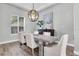Dining room with wood floors, a modern lighting fixture, and a large window providing natural light at 3716 Janus Way, Palm Harbor, FL 34685