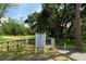 Entrance to a lush green community park with manicured lawn and mature trees at 3716 Janus Way, Palm Harbor, FL 34685
