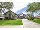 Stunning single-story home with a well-manicured lawn, mature landscaping, and a long driveway at 3716 Janus Way, Palm Harbor, FL 34685