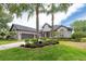 Charming one-story home featuring lush landscaping, brick-lined flowerbeds, and a two-car garage at 3716 Janus Way, Palm Harbor, FL 34685