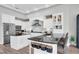 Bright kitchen featuring white cabinetry, granite counters, stainless appliances, and bar seating at the island at 3716 Janus Way, Palm Harbor, FL 34685