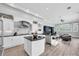 Bright kitchen featuring white cabinetry, black countertops, stainless steel appliances, and an open floorplan at 3716 Janus Way, Palm Harbor, FL 34685