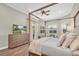 Main bedroom showcasing a four-poster bed, sitting area, and wood-look floors at 3716 Janus Way, Palm Harbor, FL 34685