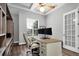 Bright home office with custom built-ins, wood floors, and a tray ceiling with fan at 3716 Janus Way, Palm Harbor, FL 34685