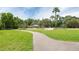 Winding park path leading to picnic area with palm trees and benches, perfect for a stroll at 3716 Janus Way, Palm Harbor, FL 34685