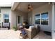 Relaxing covered outdoor patio area with comfortable seating, a ceiling fan, and beautiful plants at 3716 Janus Way, Palm Harbor, FL 34685