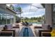 Screened-in patio featuring modern furniture, outdoor kitchen, and a swimming pool with beautiful landscaping at 3716 Janus Way, Palm Harbor, FL 34685