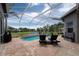 Relaxing screened-in pool and patio area with outdoor furniture, pond views, and beautiful sky at 3716 Janus Way, Palm Harbor, FL 34685