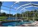 Beautiful screened-in pool and spa with scenic views of the pond and lush landscaping at 3716 Janus Way, Palm Harbor, FL 34685