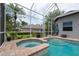 A screened-in pool and spa with brick pavers are set in a peaceful backyard at 3716 Janus Way, Palm Harbor, FL 34685