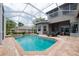 The sparkling pool and spa are surrounded by brick pavers, with seating and lovely backyard views at 3716 Janus Way, Palm Harbor, FL 34685