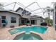 A screened-in pool and spa are surrounded by brick pavers, perfect for relaxing and entertaining at 3716 Janus Way, Palm Harbor, FL 34685
