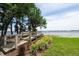 Community water access point with a wooden walkway, trees, and manicured shrubs leading to the lake at 3716 Janus Way, Palm Harbor, FL 34685