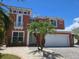 Charming two-story home with a two-car garage, complemented by lush landscaping and a beautiful palm tree at 404 Bahama Grande Blvd, Apollo Beach, FL 33572