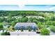 Aerial view of blue townhomes with lush landscaping and a community pond at 4528 Amberly Oaks Ct, Tampa, FL 33614