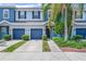Charming townhome with blue exterior, attached garages, landscaped front yard, and mature palm tree at 4528 Amberly Oaks Ct, Tampa, FL 33614