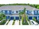 Two-story townhomes in blue, with blue garages, and landscaping at 4528 Amberly Oaks Ct, Tampa, FL 33614
